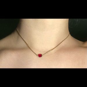 Gold choker with dark red stone
